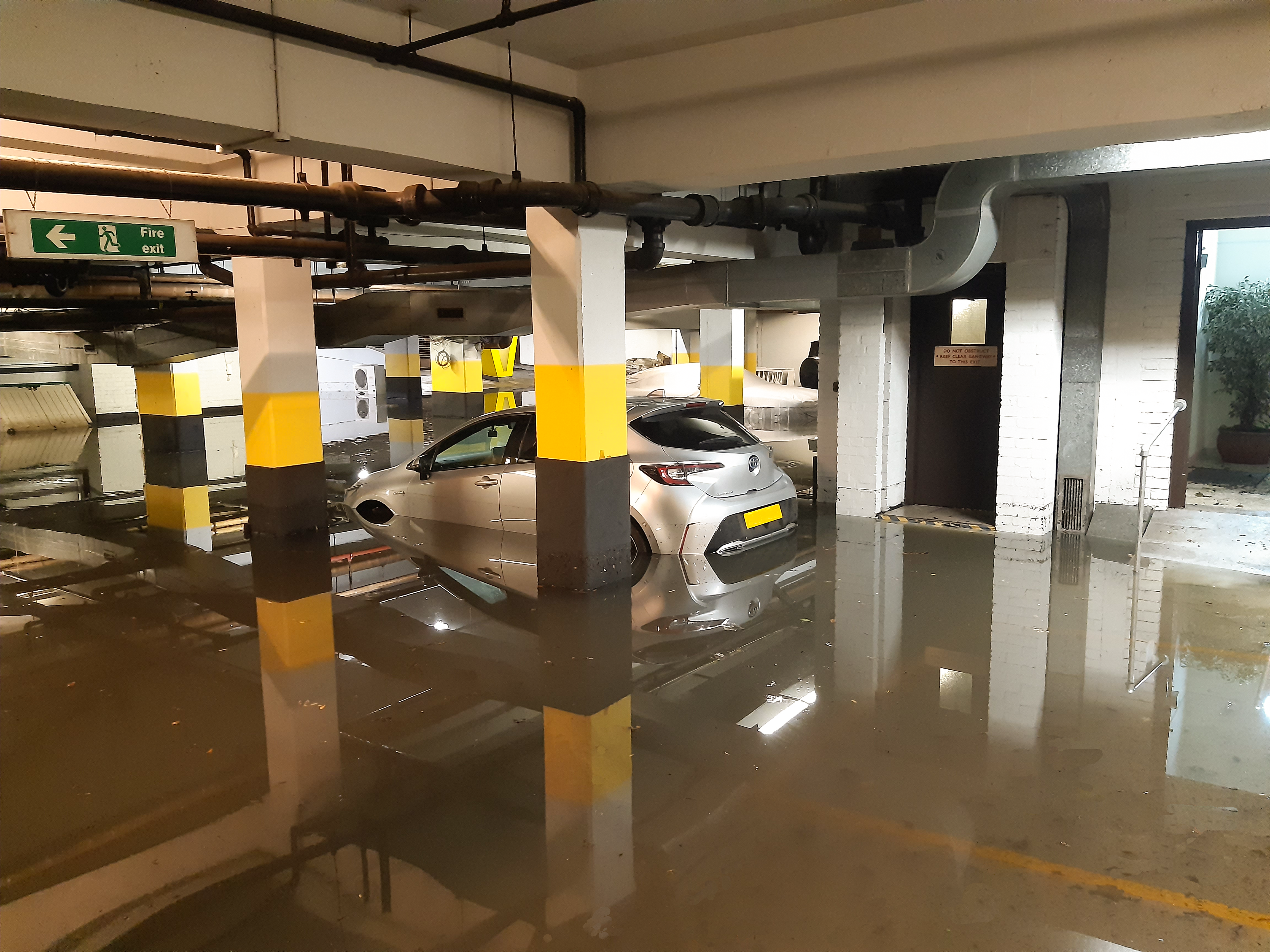 Flooded car park with sinking car